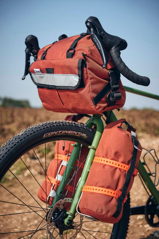 Burnt orange Road Runner handlebar bag and fork bags on the Woodland Green Fairlight Faran 2, with Shimano GRX levers.