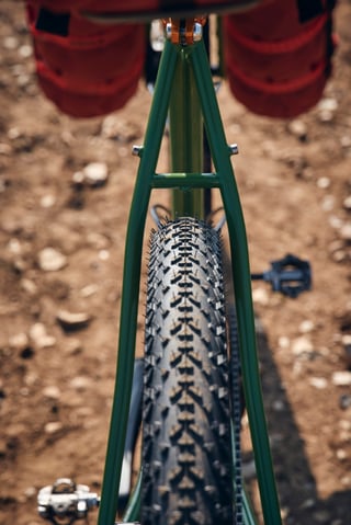 Looking down the fork of the green Fairlight Faran 2 to its Continental Race King front tyre, fork bags either side.