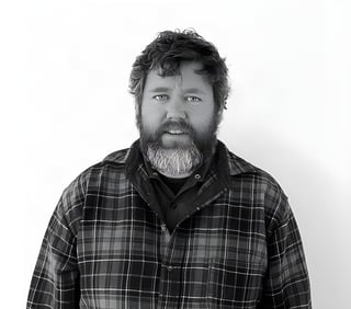 Black and white portrait of Matt Feeney, maker of Pass and Stow bike racks, in a checked shirt.