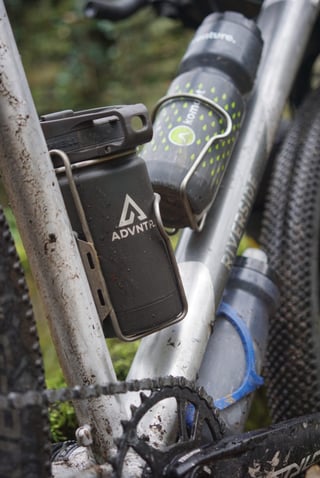 Bottle cages on the Riverside 920 seat tube and down tube holding water bottles, with a Riverside logo on the frame.