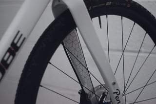 Red and blue cube motif on the inside of the Cube carbon fork leg, beside a Gravel Grinder tyre.