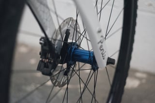 Blue front hub and disc caliper on the Cube Cross Race Pro, with the Penis sticker script on the fork leg.