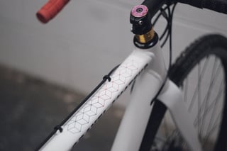 Gravel Amateur top tube with a red and blue cube pattern, doughnut stem cap and gold spacers.