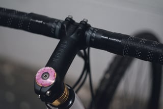 Black stem engraved with the Litany Against Fear, capped with a pink doughnut, on Ritchey Venturemax bars.