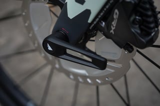 Canyon Grizl front thru-axle lever, Shimano GRX brake caliper and disc rotor in close-up.