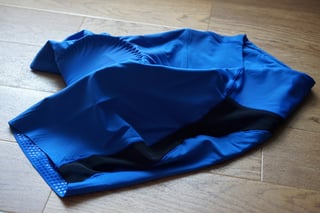 Blue Foundations liner shorts on a wooden floor, showing a black mesh side panel and a silicone-dotted leg hem.