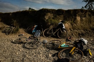 Gravel bikes, helmets and shoes left below an earth bank while riders take a wild swim at Grinduro 2021.