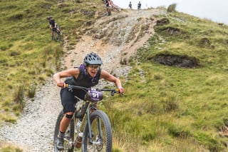Taylor Doyle grins mid-descent on a loose stony track at Grinduro 2021, number 91 on the Stayer Cycles bike.