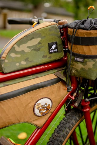 Camo and tan Wizard Works top tube, frame and stem bags on a red Clandestine steel frame at Bespoked.
