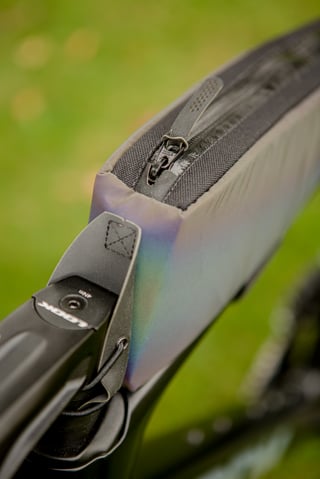 Close-up of the zip on the Look and Restrap iridescent top tube bag beside the stem.