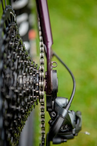 Rear derailleur, cassette and chain beside the purple dropout of the Lord Cycles Nomad.