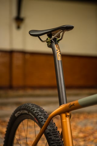 ENVE seatpost and saddle on the copper and grey Quirk Cycles Superchub, above a Schwalbe tyre.