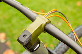 Green anodised stem on the Quirk Superchub, with orange cables running over the handlebar.