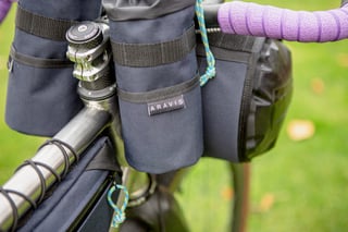 Aravis Bag Works feed pouch and handlebar bags clustered around the stem, with a blue and green cord pull.