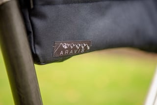 Aravis Bag Works logo patch with a mountain outline on a navy bag.