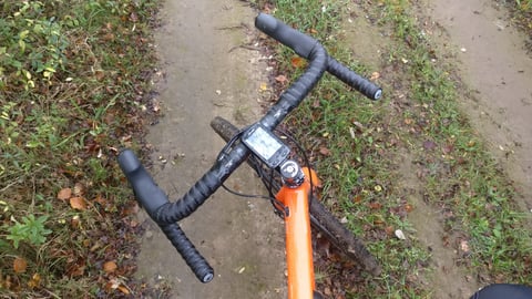 Easton EC70 AX carbon handlebar wrapped in black tape on a Mason Bokeh gravel bike, seen from above on a muddy track.