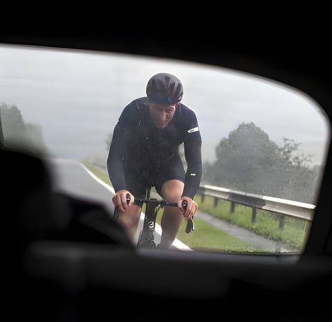 Rider in the rain seen through a car window during Albion Cycling's Heading North London to Edinburgh ride.