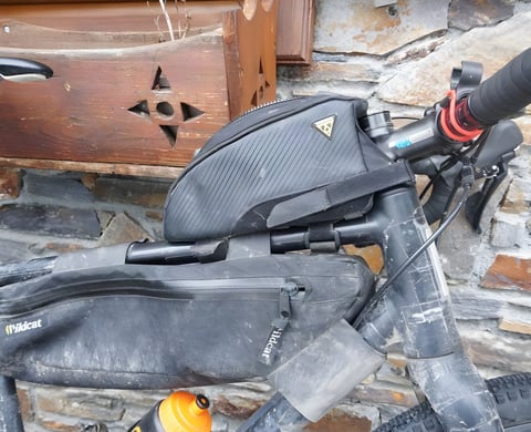 Topeak Fuel Tank top tube bag mounted above a Wildcat frame bag on a muddy bikepacking bike.