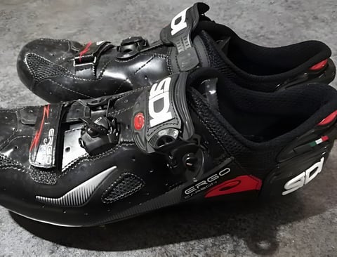 Pair of black Sidi Ergo 4 Carbon road shoes with dial and strap closures, seen from the side.