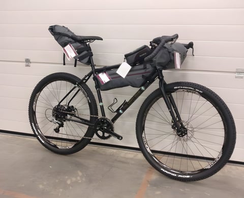 Light Blue Darwin One By MT steel bike fitted with Passport frame, seat and bar bags, side view.