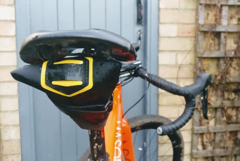 Side view of the Apidura Expedition Tool Pack hanging under a saddle on a Deda Superleggera seatpost.
