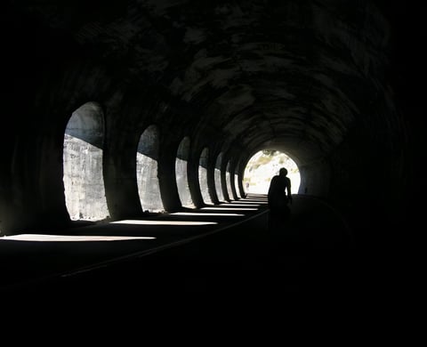 Rider silhouetted in a long arched road tunnel on the Turin Nice Rally route, the event James Olsen founded.