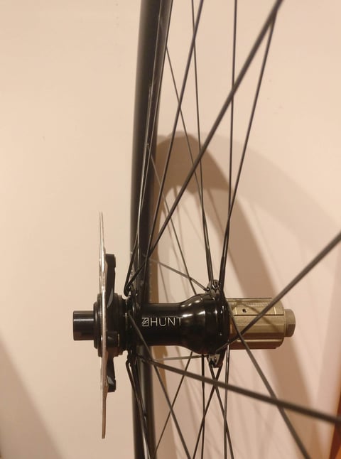 Side view of the Hunt-branded black hub on the 30 Carbon Gravel wheelset, with rotor and freehub body.