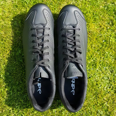 Pair of black dhb Dorica MTB lace-up shoes seen from above on a grass lawn.