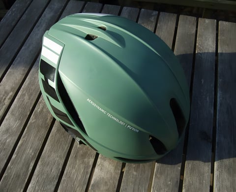 HJC Furion aero helmet in Matte Olive green on a wooden table, seen from a three-quarter angle.