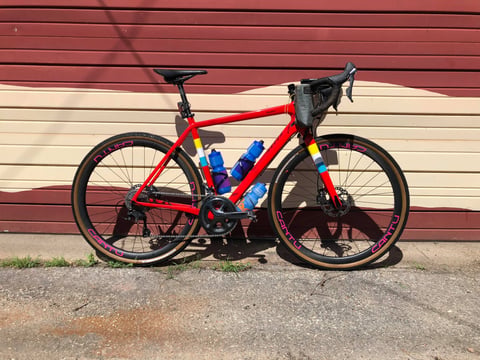 Paul Errington's red Salsa Warbird Carbon with Cantu carbon wheels against a wall before the Dirty Kanza 200.