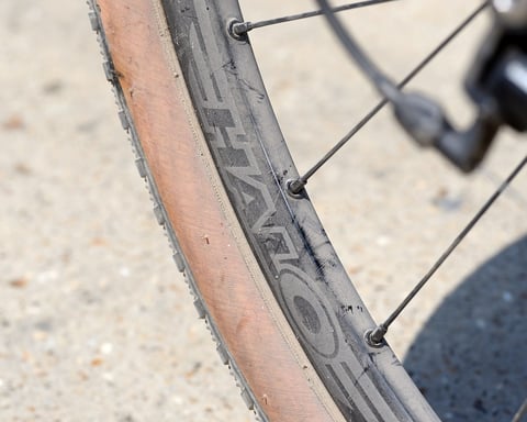 Halo Vapour GXC rim with the Halo logo and a tan-wall tyre on a sunlit gravel surface.