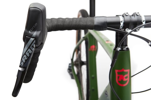 SRAM Force brake lever on the drop bar of the green Kona Libre DL, with the Kona head badge behind.