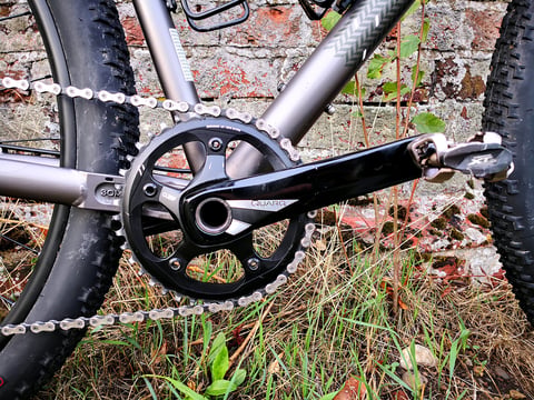 Quarq crankset and Shimano XT pedal on the Bombtrack Hook EXT, with the cast chainstay yoke behind.
