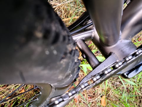 Close-up of the Hook EXT chainstay and bottom bracket yoke, showing clearance beside the WTB Nano tyre.