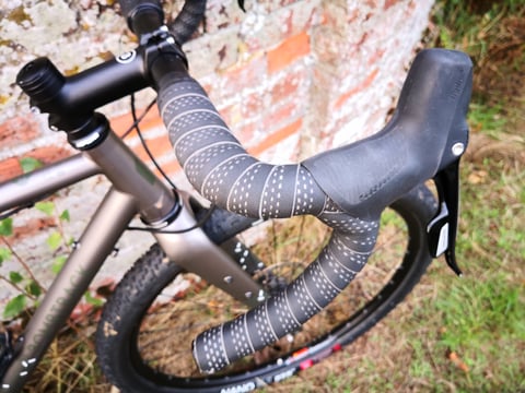 Bombtrack CX-10 flared drop bar with patterned tape and SRAM Rival lever on the Hook EXT, 650b wheel below.
