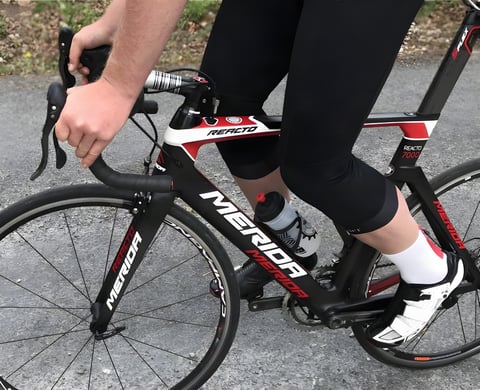 Rider's legs in Galibier 3/4 Peloton Bib Knickers, ending below the knee, on a Merida Reacto road bike.