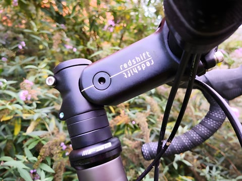 Close-up of a Redshift ShockStop suspension stem fitted to a bike's steerer tube.