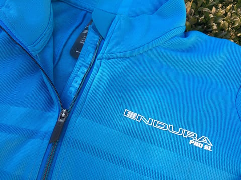Close-up of the Endura Pro SL jersey's zip pull, collar and printed chest bands, with the chest logo.