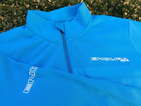 Hi Viz blue Endura Pro SL jersey laid flat, with the front zip, chest logo and sleeve branding.
