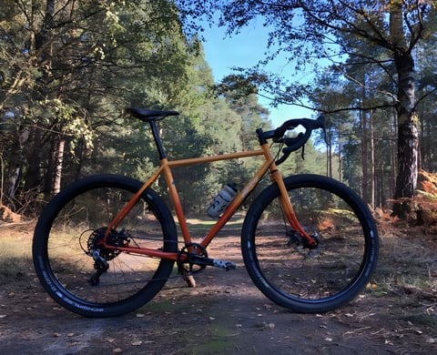 Orange All-City Gorilla Monsoon monster-cross bike with Schwalbe G-One tyres on a forest track.
