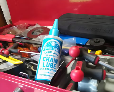 Juice Lubes Chain Juice Wet chain lube bottle standing in a red toolbox full of tools.