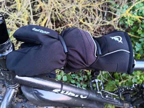 SealSkinz lobster mitts held on a Surly's top tube by the Super 8 strap, just behind the stem.