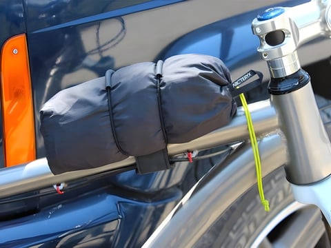 Super 8 strap carrying a rolled Arc'teryx stuff sack along the top tube of a silver bike.