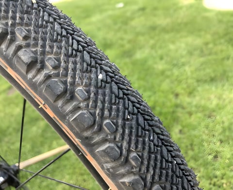 Close-up of the ribbed, wedge-shaped tread on a tanwall WTB Venture 650b x 47 gravel tyre.