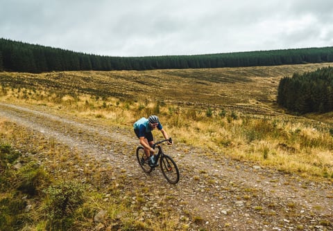 Rider on a Salsa Warroad gravel bike climbs a stony forestry track on the Frontier 300 route preview in the Borders.