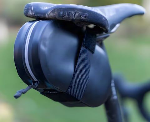 Arundel Gordo saddle bag in black mounted under a WTB saddle, shown from the side.