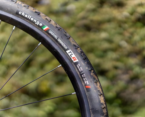 Challenge Gravel Grinder TLR 700x42 gravel tyre sidewall, with logo and size markings, mounted on a black rim.