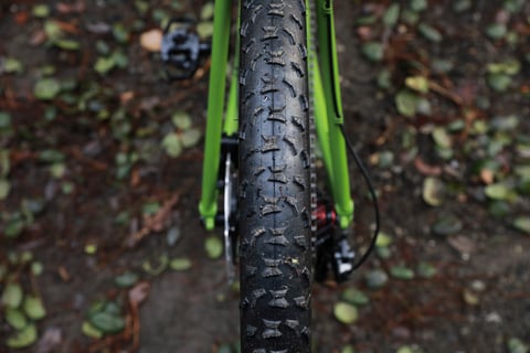 Rear tyre sitting between the green chainstays of the Ritchey Outback V2, showing the tyre clearance.
