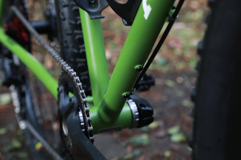 Green steel down tube and seat tube of the Ritchey Outback V2 meeting at the bottom bracket, with chainring and chain.