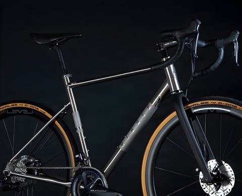 Ribble CGR Ti titanium gravel bike with Shimano Ultegra and tan-wall Schwalbe G-One tyres against a black backdrop.